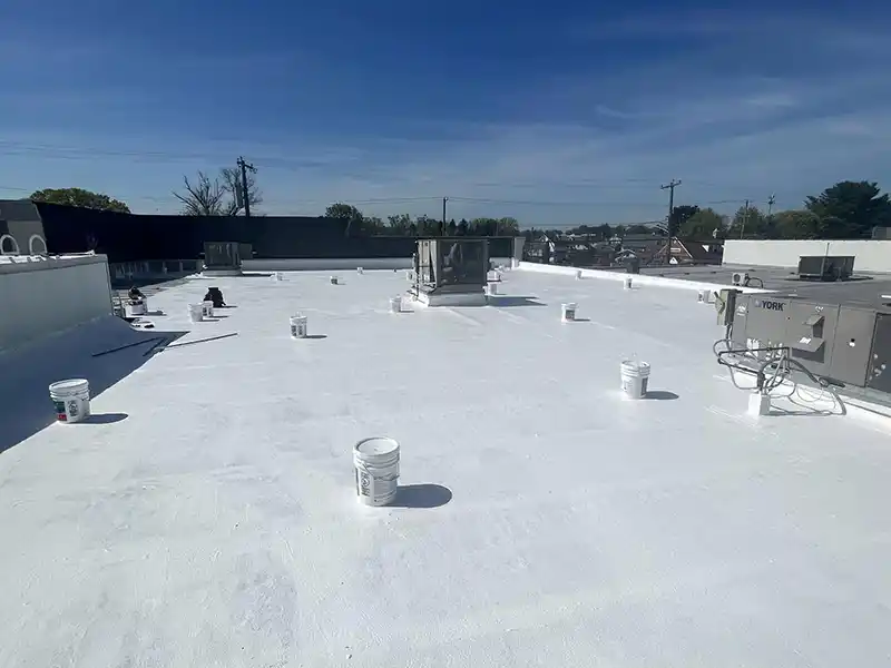 Flat commercial roof with a new white silicone system installed by Jim Miller Inc.
