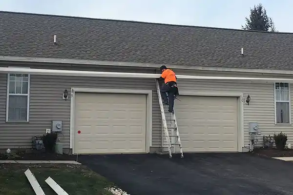 Jim Miller Inc. crew member installing a new gutter system on a home