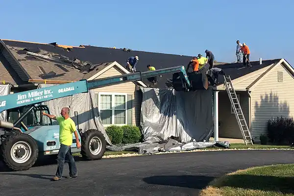 Jim Miller Inc. team removing shingles from a roof and getting it ready for a replacement